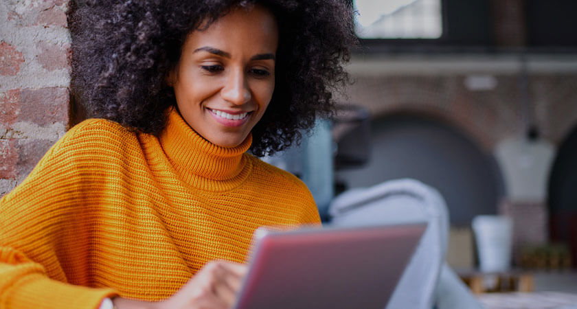 Woman in orange shirt looking at tablet