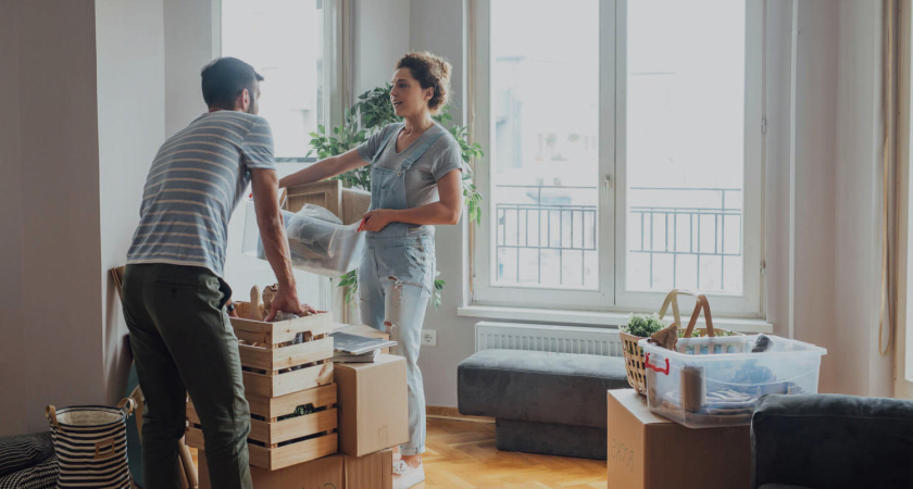 Two people unpacking boxes in new house